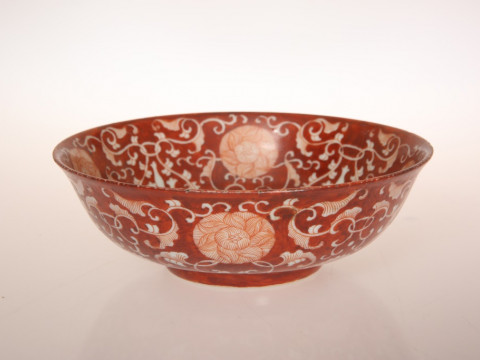 A CHINESE IRON RED REVERSE DECORATED BOWL, decorated with a continuous...