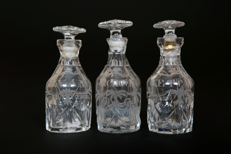 A SET OF THREE GEORGE III ENGRAVED AND CUT-GLASS CRUET BOTTLES, each of mallet form, with mushroom stopper and star-cut base, engraved 'Anchovey', 'Kyan' and 'Ketchup'. 9.5cm