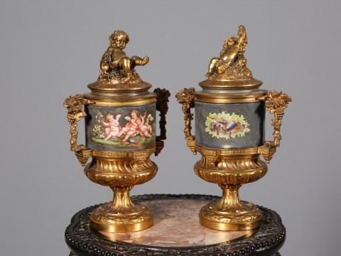 PAIR OF GILT-METAL URNS AND COVERS, each cover with the figure of a putti,...