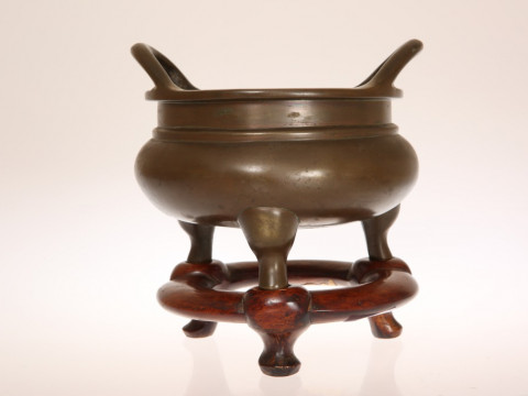 A CHINESE PATINATED BRONZE TWO-HANDLED CENSER, of squat circular form,...