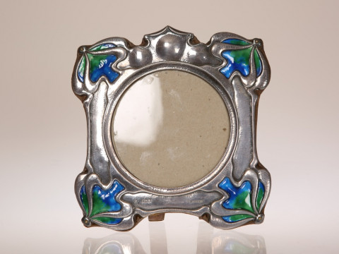 A SILVER AND ENAMEL PHOTOGRAPH FRAME IN THE ART NOUVEAU TASTE, William...