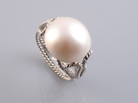A BLISTER PEARL RING, the large round blister pearl set simply within...
