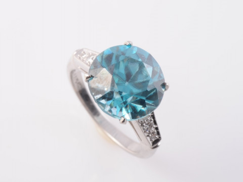A BLUE ZIRCON AND DIAMOND RING, the round cut blue zircon four claw set...