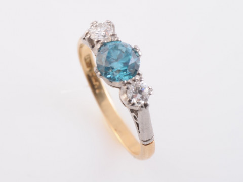 A BLUE ZIRCON AND DIAMOND RING, the round cut claw set blue zircon set...