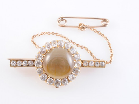 A CATS EYE CHRYSOBERYL AND DIAMOND BROOCH, circa 1880-1890, the round...