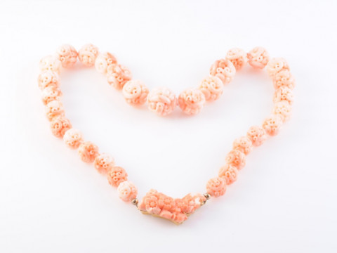 A CHINESE CORAL NECKLACE, the thirty-one graduating carved coral beads...