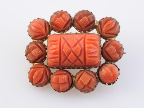 A CORAL BROOCH, circa 1880, the central rectangular carved coral plaque...