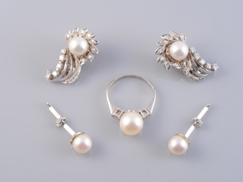 A CULTURED PEARL AND DIAMOND RING, the single cultured pearl set between...