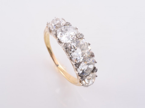 A DIAMOND RING, circa 1880-1890, the five graduating old cushion cut diamonds...