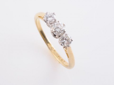A DIAMOND RING, the three slightly graduating brilliant cut diamonds each...