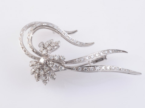 A DIAMOND SET SPRAY BROOCH, of four curved strands each set to the entirety...