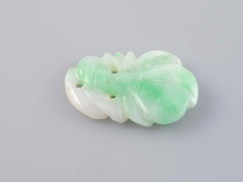A JADEITE PLAQUE, of simple carved form. Length 2cm. Weight 1.3gms.