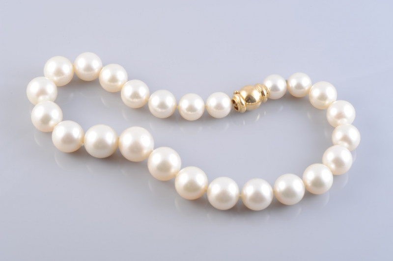 A WEMPE CULTURED PEARL NECKLACE, the twenty-four graduating cultured pearls each strung knotted onto a heavy integral tongue ball clasp with moulded details. Clasp stamped 750. Length 36cm. Weight 89gms.