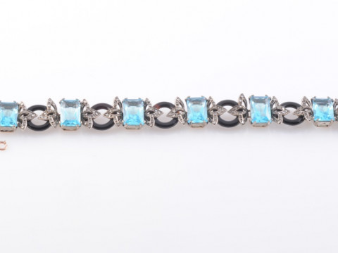 AN ART DECO DIAMOND, BLACK ONYX AND BLUE ZIRCON BRACELET, the seven rectangular...
