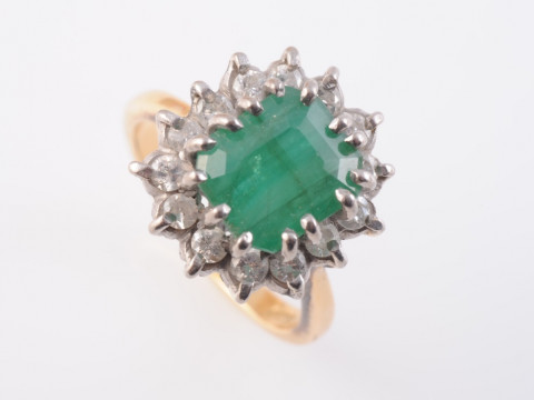 AN EMERALD AND DIAMOND RING, the square cut emerald fourteen claw set...