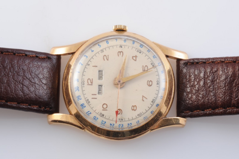 AN 18 CARAT GOLD TRIPLE DATE CALENDAR MANUAL WIND WRISTWATCH, circa 1940's, day and month apertures, subsidiary seconds dial. Case 31mm wide