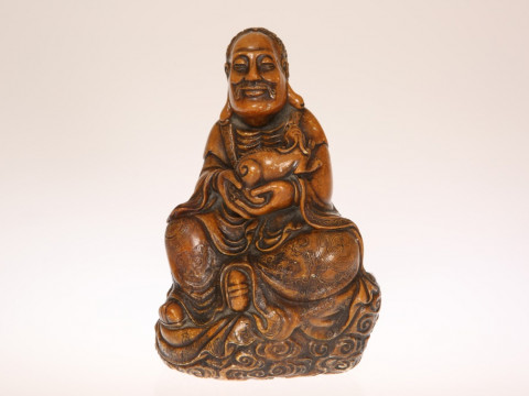 A CHINESE CARVED SOAPSTONE FIGURE OF A SEATED LOHAN, on a cloud-carved...