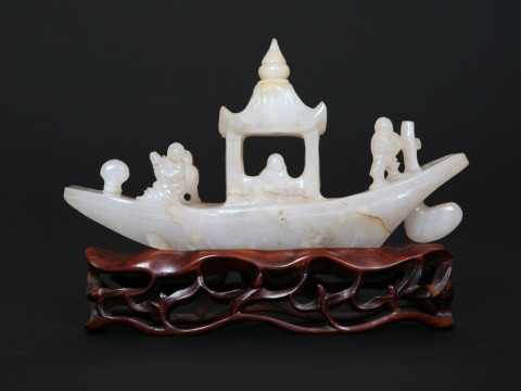 A CHINESE CARVED JADE MODEL OF A RIVER BOAT, the stone grey/white, mounted...