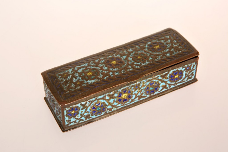AN INDO PERSIAN ENAMELLED BOX, 18th/19th Century, rectangular with hinged lid, chased in low relief with scrolling foliage and picked out in turquoise, cobalt blue and yellow enamels. 13cm