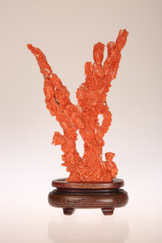 A CHINESE CARVED RED CORAL FIGURE GROUP, the branches modelled as women and girls in varying poses amidst flowerheads, on a hardwood stand, in a fitted case. Excluding stand 20cm