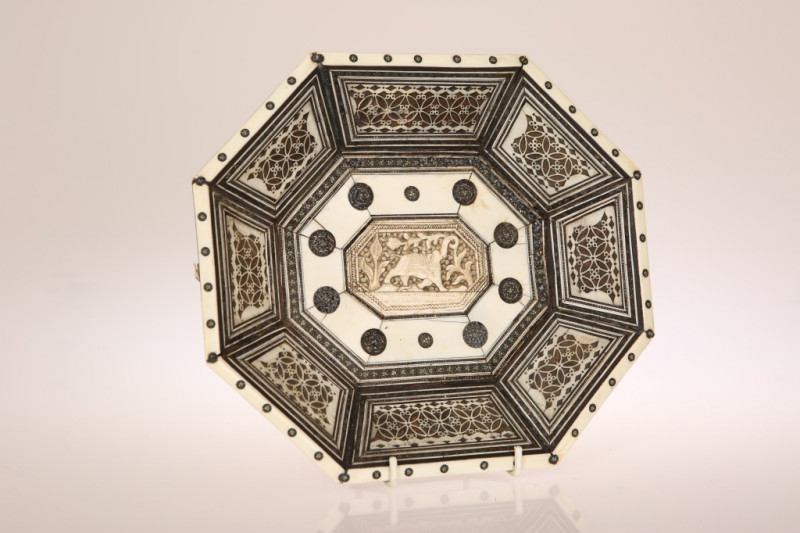 A 19th CENTURY INDIAN VIZAGAPATAM DISH, of shaped octagonal form, the well centred by a panel carved with an elephant within a border of geometric roundels, the sides with pierced stylised foliate panels. Width 24cm