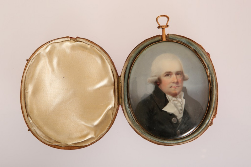 ENGLISH SCHOOL, LATE 18th CENTURY, A PORTRAIT MINIATURE OF A GENTLEMAN IN A COAT WITH SILVER BUTTONS, watercolour on ivory, oval, unsigned, in an engraved gilt metal frame with blue glass foil-backed reverse and suspension loop, contained in a fitted red 