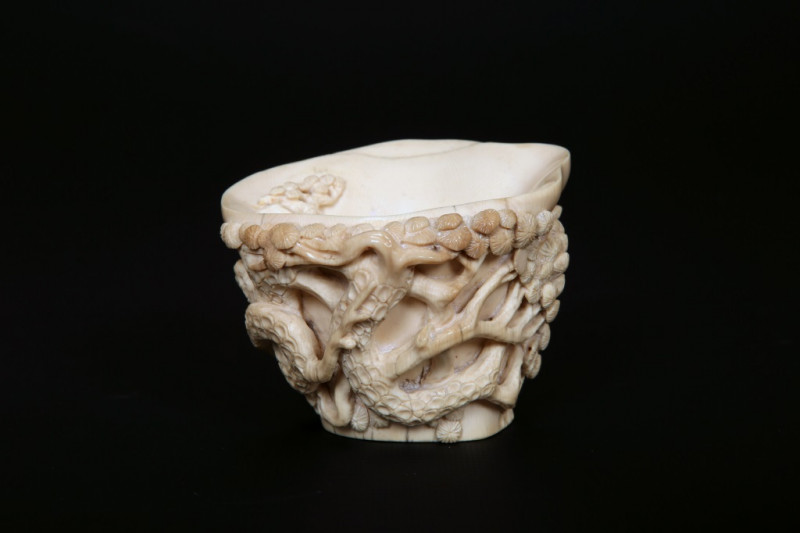 A GOOD QUALITY CHINESE IVORY LIBATION CUP, 19th CENTURY, carved in high relief with branches of pine. 7cm by 9cm