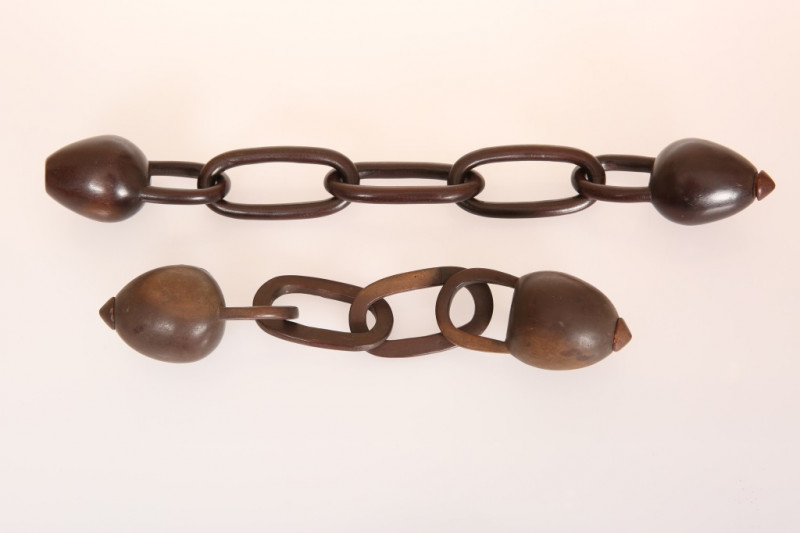 FOUR ZULU OR TSONGA CARVED HARDWOOD SNUFF CONTAINERS, probably 19th Century, two united by chain-like wooden links (one container lacks stopper), the other on two flattened wooden links with the fourth container detached. Overall length of first 31.5cm