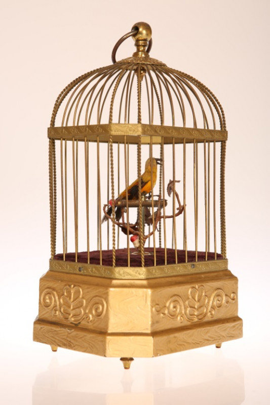 A SINGING BIRD AUTOMATON, LATE 19TH/EARLY 20TH CENTURY, in gilt wirework cage, clockwork movement to base. 28cm high