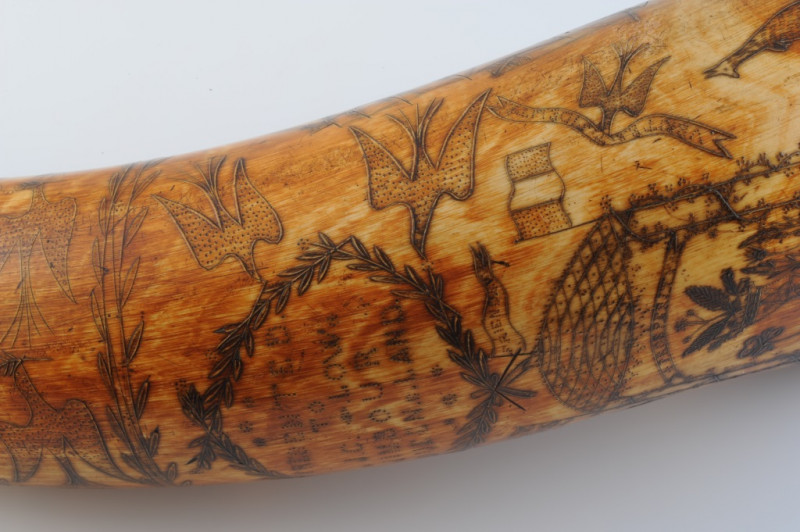 AN AUSTRALIAN POWDER HORN, with scrimshaw decoration of a ship in full sail, opposed by an inscription 'Presented to J. C. Low.....Jimbour, Queensland 1862' in a cartouche amidst birds and flags, inscribed with makers name Colvin or Corvin?. Length 33cm
