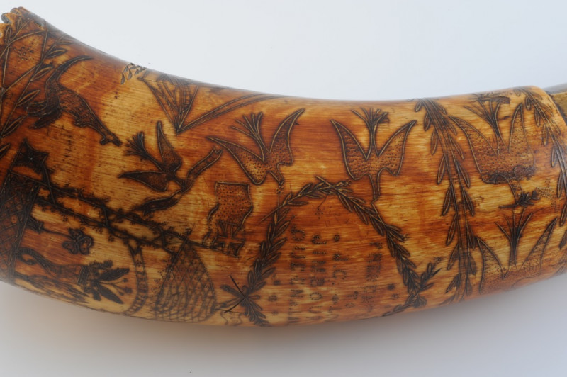 AN AUSTRALIAN POWDER HORN, with scrimshaw decoration of a ship in full sail, opposed by an inscription 'Presented to J. C. Low.....Jimbour, Queensland 1862' in a cartouche amidst birds and flags, inscribed with makers name Colvin or Corvin?. Length 33cm