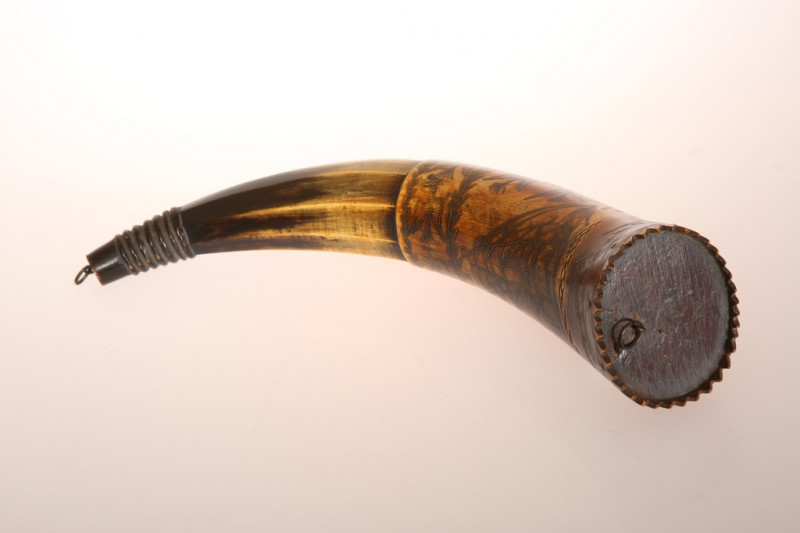AN AUSTRALIAN POWDER HORN, with scrimshaw decoration of a ship in full sail, opposed by an inscription 'Presented to J. C. Low.....Jimbour, Queensland 1862' in a cartouche amidst birds and flags, inscribed with makers name Colvin or Corvin?. Length 33cm