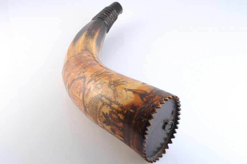 AN AUSTRALIAN POWDER HORN, with scrimshaw decoration of a ship in full sail, opposed by an inscription 'Presented to J. C. Low.....Jimbour, Queensland 1862' in a cartouche amidst birds and flags, inscribed with makers name Colvin or Corvin?. Length 33cm