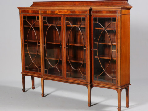 AN EDWARDIAN INLAID MAHOGANY BREAKFRONT BOOKCASE, with astragal glazed...
