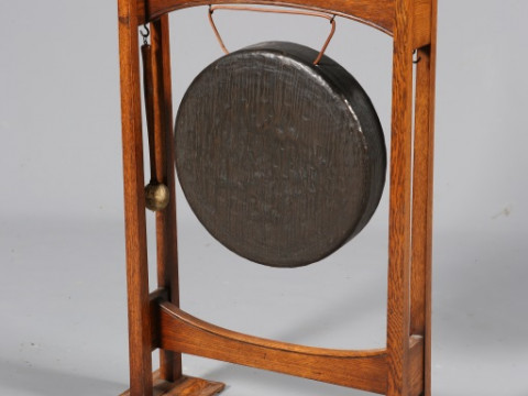 AN ARTS AND CRAFTS OAK DINNER GONG, with four square section columns,...