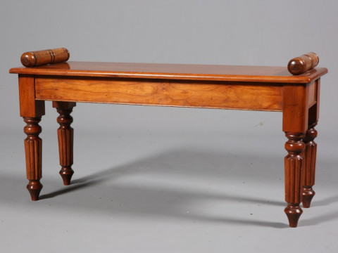 A MAHOGANY WINDOW SEAT IN WILLIAM IV STYLE, raised on reeded legs. 100cm