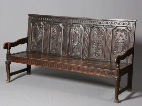 A LATE GEORGIAN OAK SETTLE, with later carved five panel back of a soldier...
