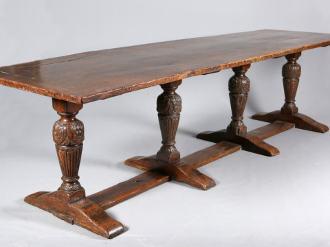 A LARGE OAK REFECTORY TABLE, the plank top raised on four central carved...