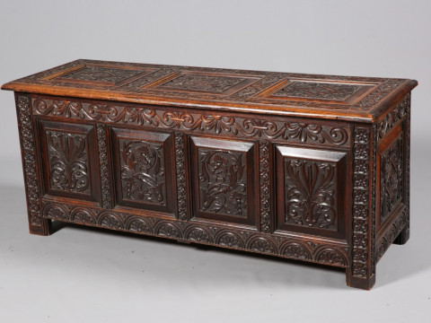 A LARGE CARVED OAK COFFER, 19TH CENTURY, the three-panel lid carved with...