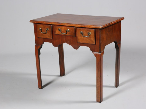 A GEORGE III MAHOGANY LOWBOY, the moulded rectangular top above three...