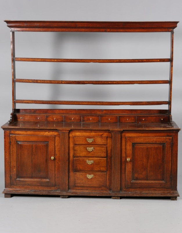 A GOOD GEORGE III OAK DRESSER AND RACK, the open rack with three shelves and moulded cornice, the base with seven short drawers above a moulded rectangular top above four graduated short drawers flanked by fluted pilasters further flanked by a pair of fie