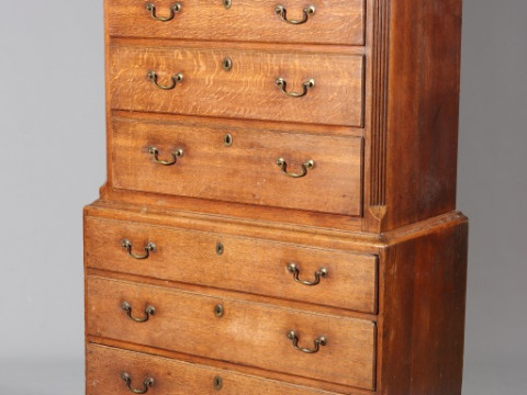 A GEORGE III OAK CHEST ON CHEST, the upper section with dentil moulding...