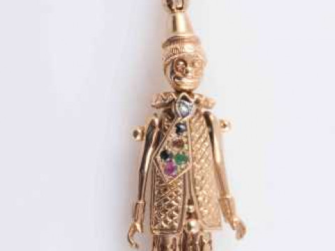 A 9 CARAT GOLD AND JEWELLED ARTICULATED CLOWN PENDANT, on a 9 carat gold...