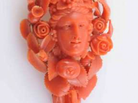 A CARVED CORAL PENDANT BROOCH, elaborately carved to depict a woman's...