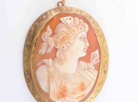 A SHELL CAMEO BROOCH, circa 1900, the oval cameo carved to depict the...