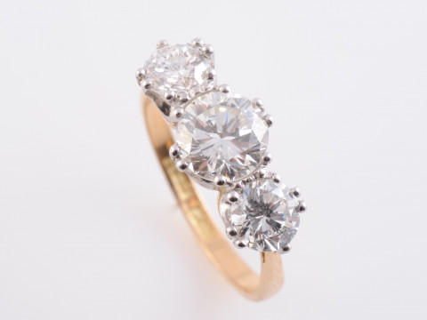 A DIAMOND RING, the three graduating brilliant cut diamonds each claw...