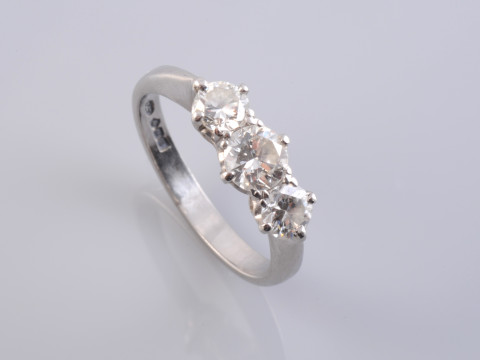 A DIAMOND RING, the three slightly graduating brilliant cut diamonds each...