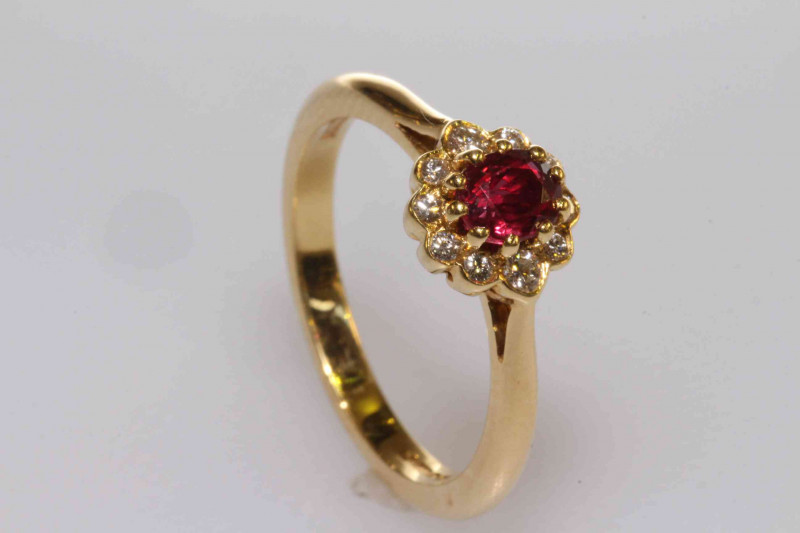 18 carat gold, oval ruby and round brilliant cut diamond cluster ring, size M