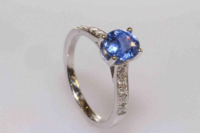18 carat gold, oval sapphire and round brilliant cut diamond shoulder ring, sapphire approximately 1.54 carats, size K