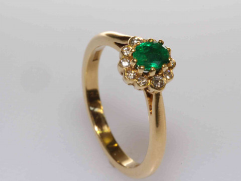 18 carat gold oval emerald and round brilliant diamond cluster ring, size...